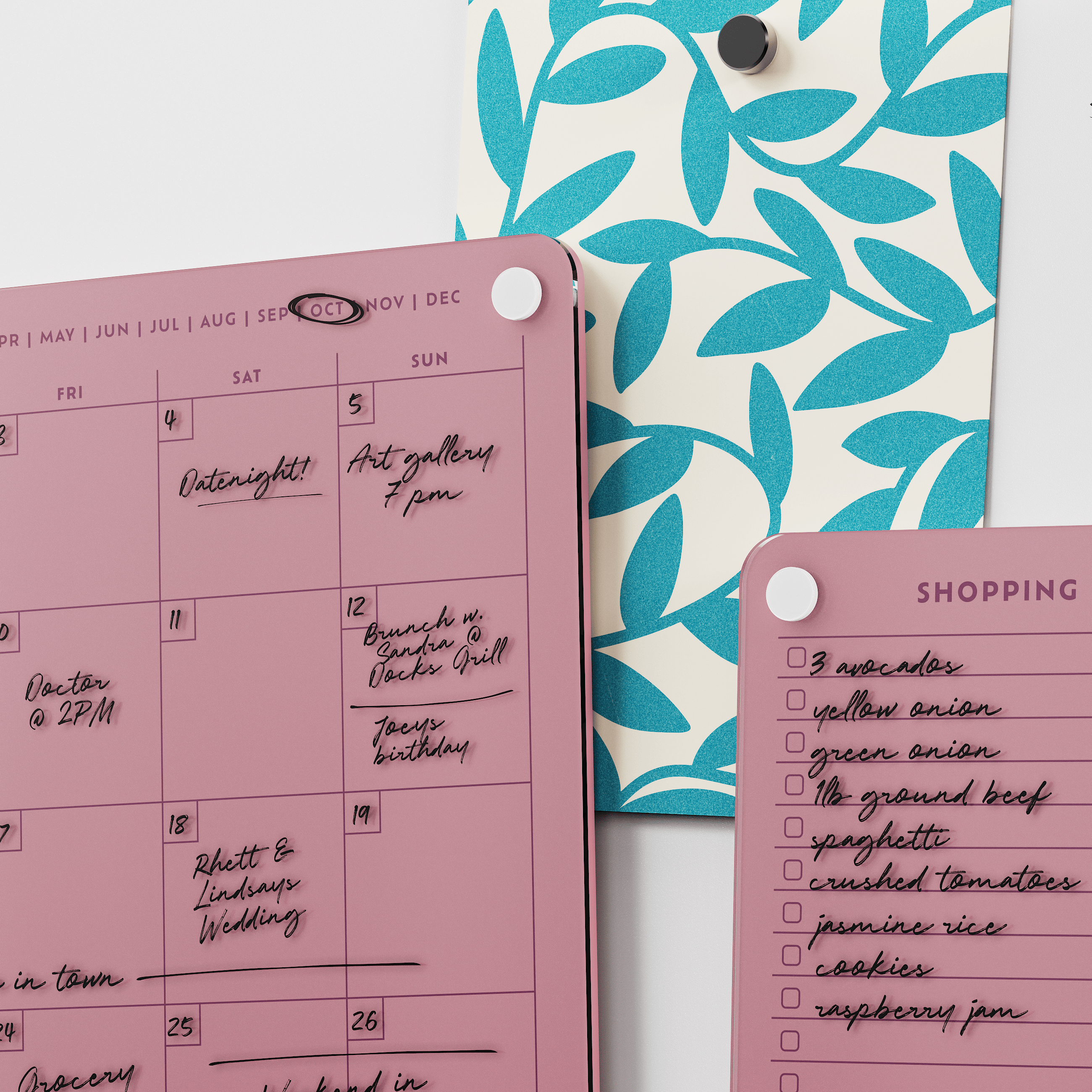 Close-up of the Plum monthly calendar and shopping list boards with handwritten plans and groceries